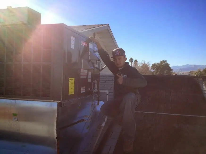 HVAC technician performing AC Tune-Up on a rooftop unit in Iowa Park